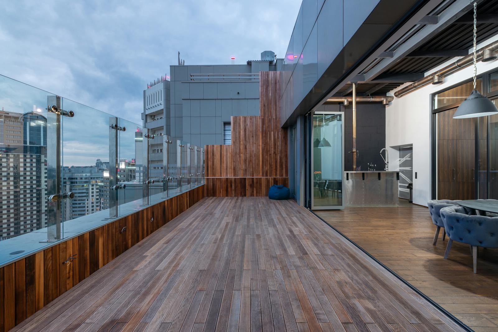 Spacious modern penthouse terrace with wooden deck at sunset