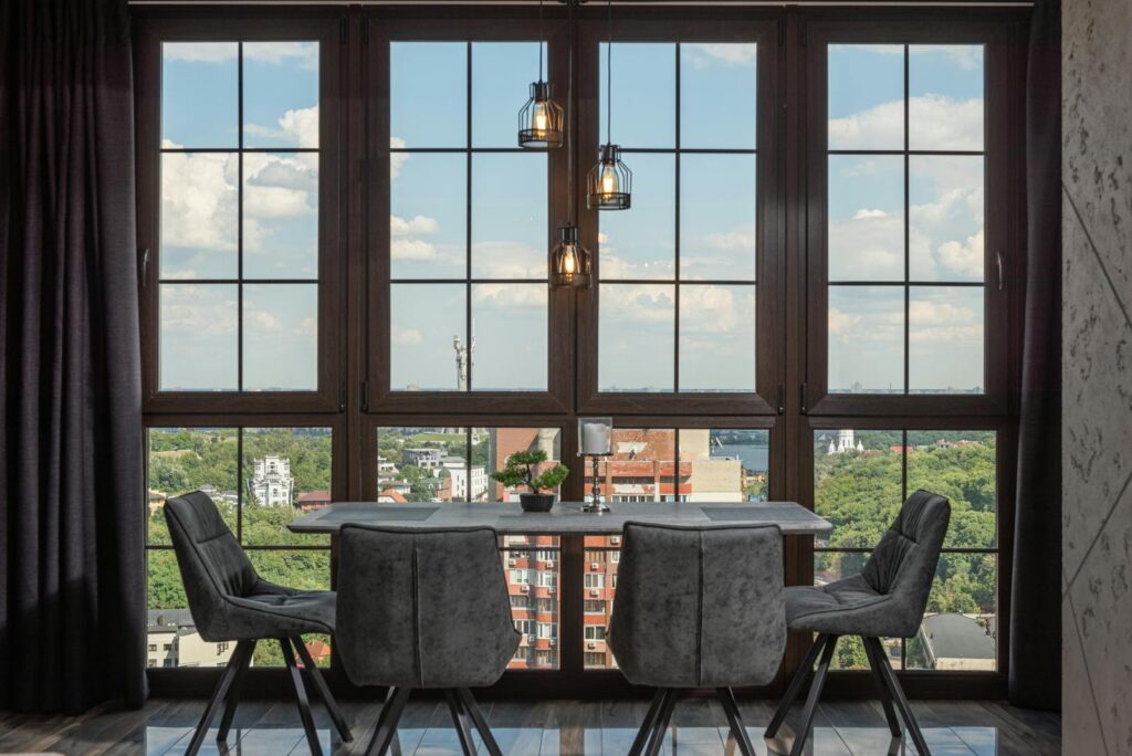 Stylish penthouse dining room with floor-to-ceiling windows overlooking city