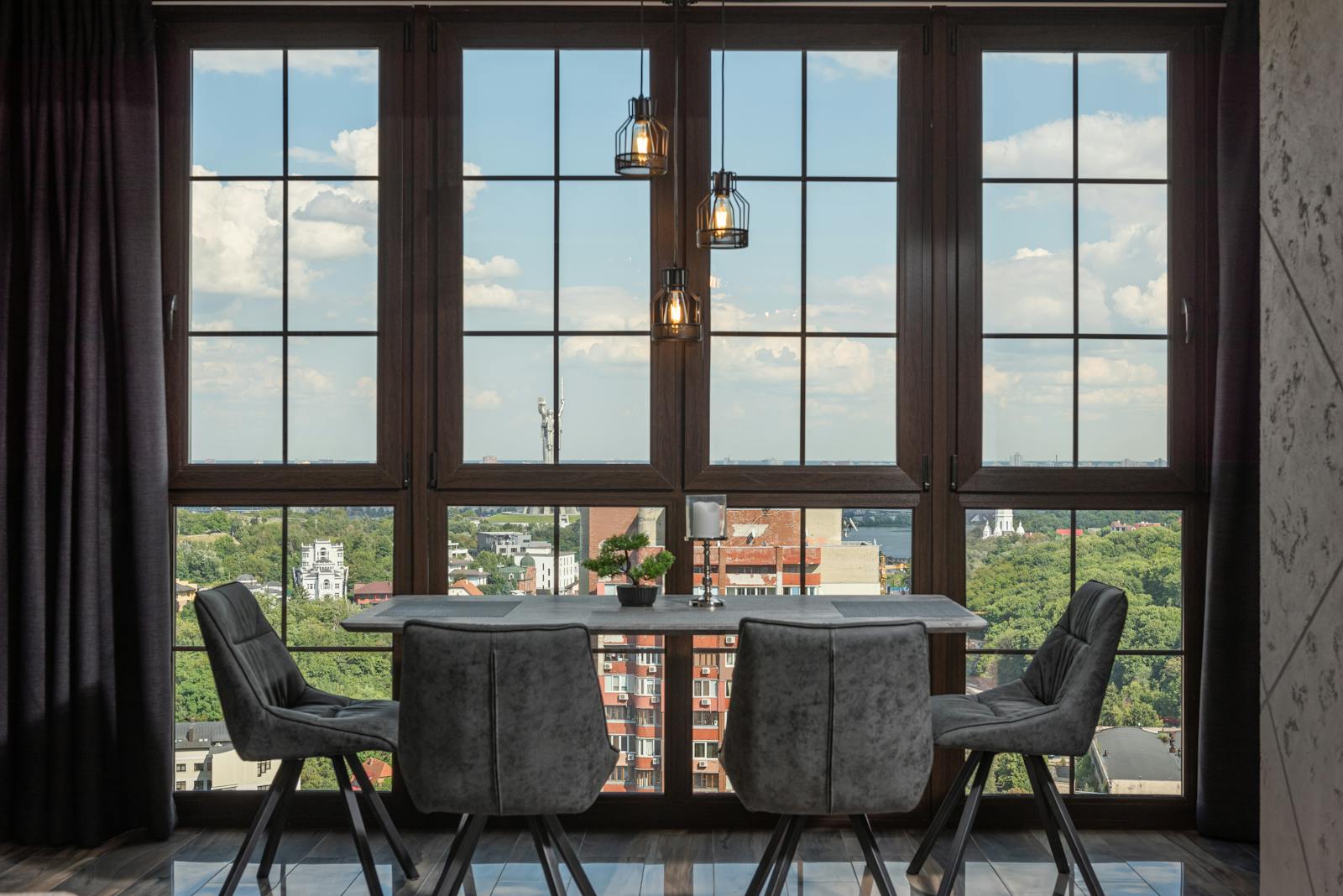 Stylish penthouse dining room with floor-to-ceiling windows overlooking city